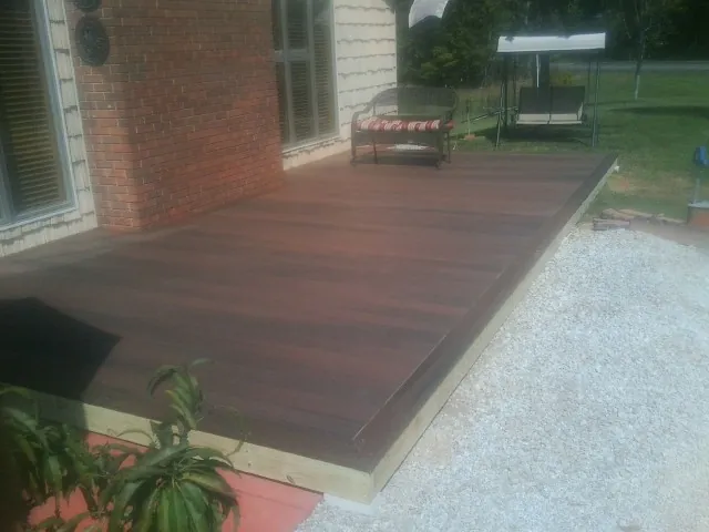 Freshly stained wood deck built against a brick home in Sandpoint