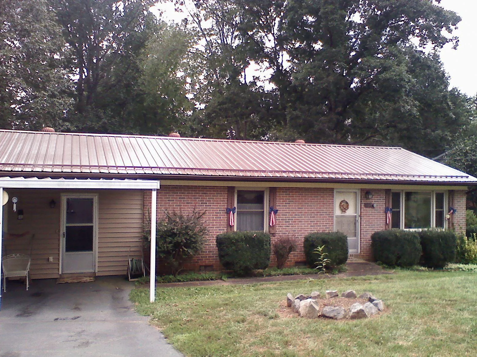 Bronze metal roof and carport on a brick ranch home — Roof Repair work by our crew in Sandpoint